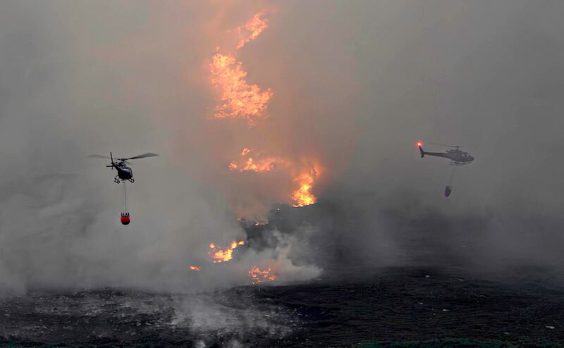 Helicopters drop water on the fire. Photograph: Phil Greaves