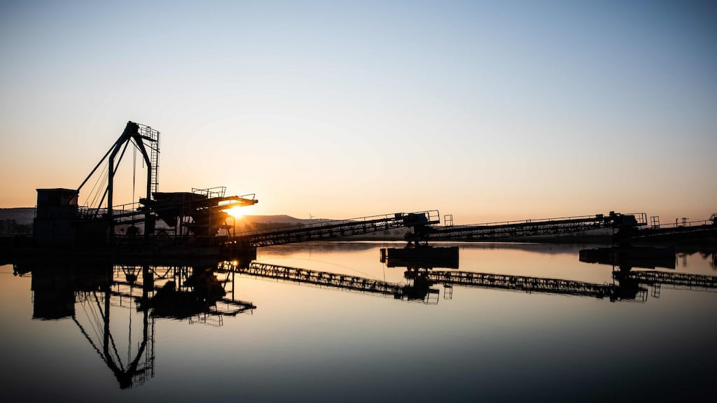 Economic horizon: The sun rises behind a processing plant at a quarry pond near Goettingen in Rosdorf, western Germany. Photograph: Swen Pförtner / dpa / AFP