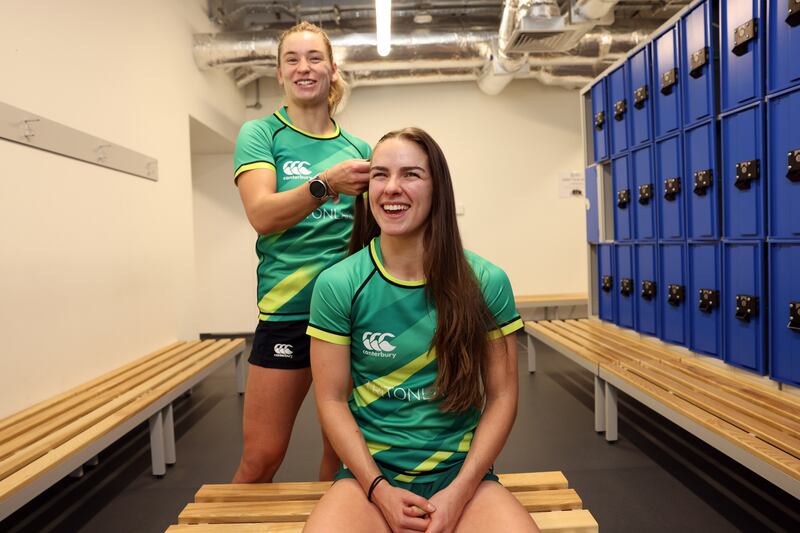 Kathy Baker braids Katie Farrell's hair in the changing rooms. Both are members of the Ireland Women's Sevens rugby team. Photograph: Laura Hutton