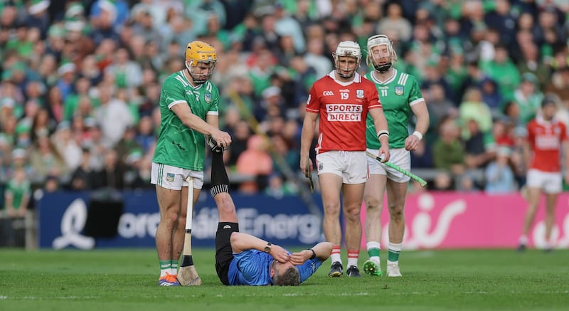 Referee Thomas Walsh receives assistance from Limerick's Adam English after suffering cramp during extra time. Photograph: Laszlo Geczo/Inpho