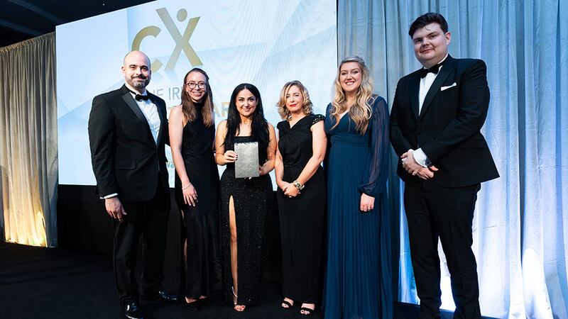 Charlotte Buckley, awards judge, presents the CX impact in professional services award to the Fragomen Ireland team.