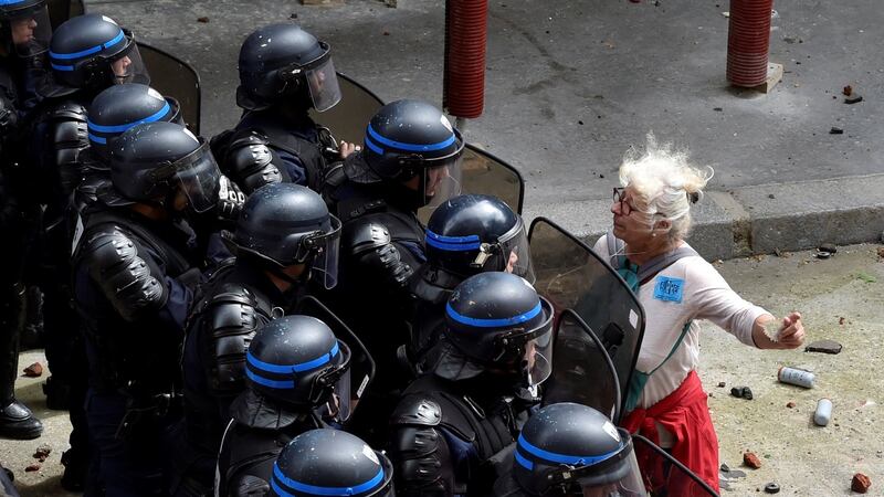A woman stands in front of police officers as they block access to a street during a protest against proposed labour reforms in Paris in June 2016. Photograph: Alain Jocard/AFP/Getty Images