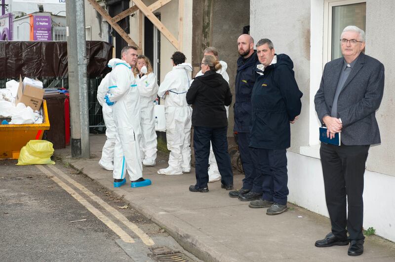 Gardaí and Fr Bill Bermingham (right) after human remains are found following the search and excavation at the Satchwell  house in Youghal. Photograph: Michael Mac Sweeney/Provision