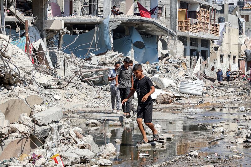 Boys walk on dry bricks to traverse a puddle of sewage water amid mounds of trash and rubble in the Jabalia camp for Palestinian refugees in the northern Gaza Strip on Wednesday. Photograph: Omar Al-Qattaa/AFP via Getty