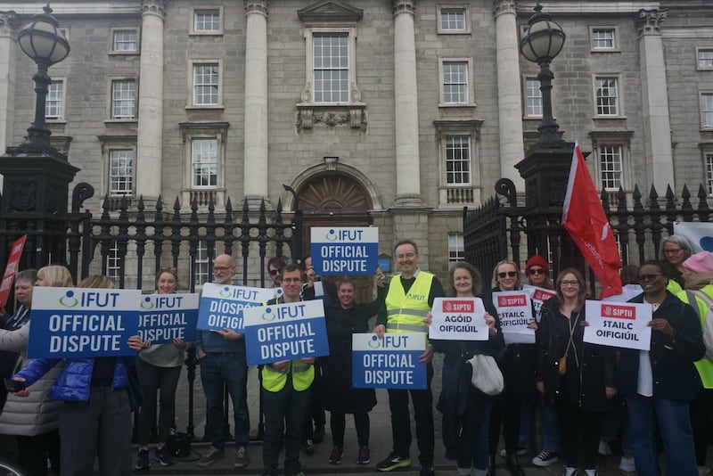 Trinity academic and Irish Federation of University Teachers activist John Walsh, wearing a hi-vis jacket, stands with others on the picket line in front of the closed front doors to Trinity college. Photograph: Emmett Malone