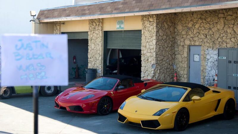 A sign that reads “Justin Bieber was here” stands in front of the two sports cars located in a police impound lot in Miami Beach, Florida today. Photograph:  Gary I Rothsein/Reuters.