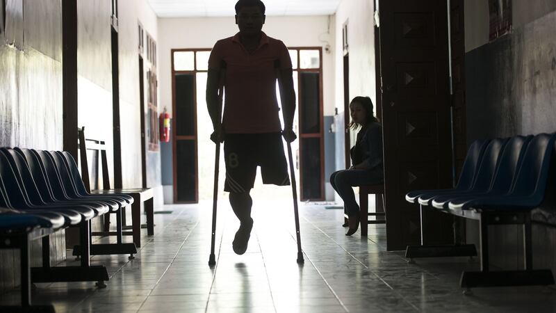 A man arrives at the Cope centre in Vientiane, Laos. Cope was formed in 1997 in response to the need to provide UXO (unexploded ordnance) survivors with  care and support, and orthotic and prosthetic devices which are made on site at the centre. Photograph: Brenda Fitzsimons