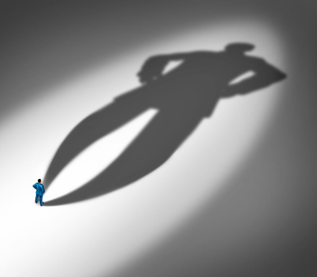 Project confidence as a businessman standing with a huge cast shadow as a metaphor for a confident personality and feeling of certainty in a 3D illustration style.