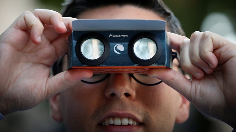 A man looks through  solar viewing glasses to watch the total solar eclipse in New York City, US. Photograph: Brendan McDermid/Reuters