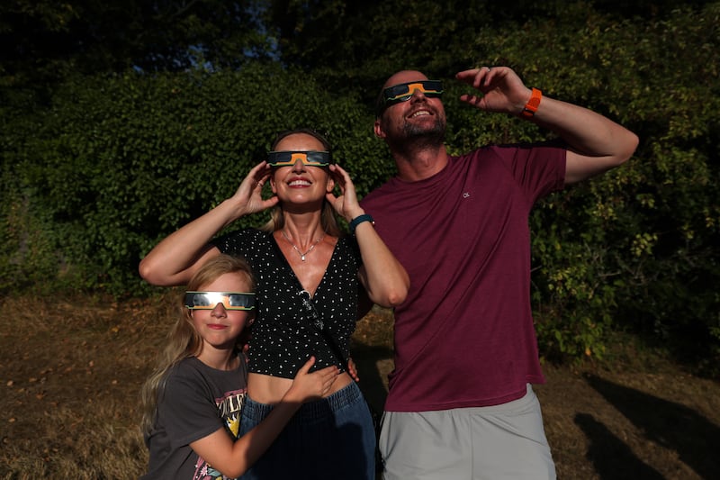 Kelly Mansik (nine) and her parents Elena and Igor Mansik watch the solar eclipse at Dunsink Observatory. Photograph: Clodagh Kilcoyne/The Irish Times