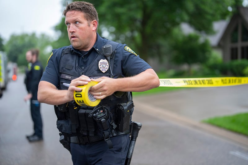 A police officer sets up a perimeter at the crime scene. Photograph: Alex Kormann/ Star Tribune via AP
