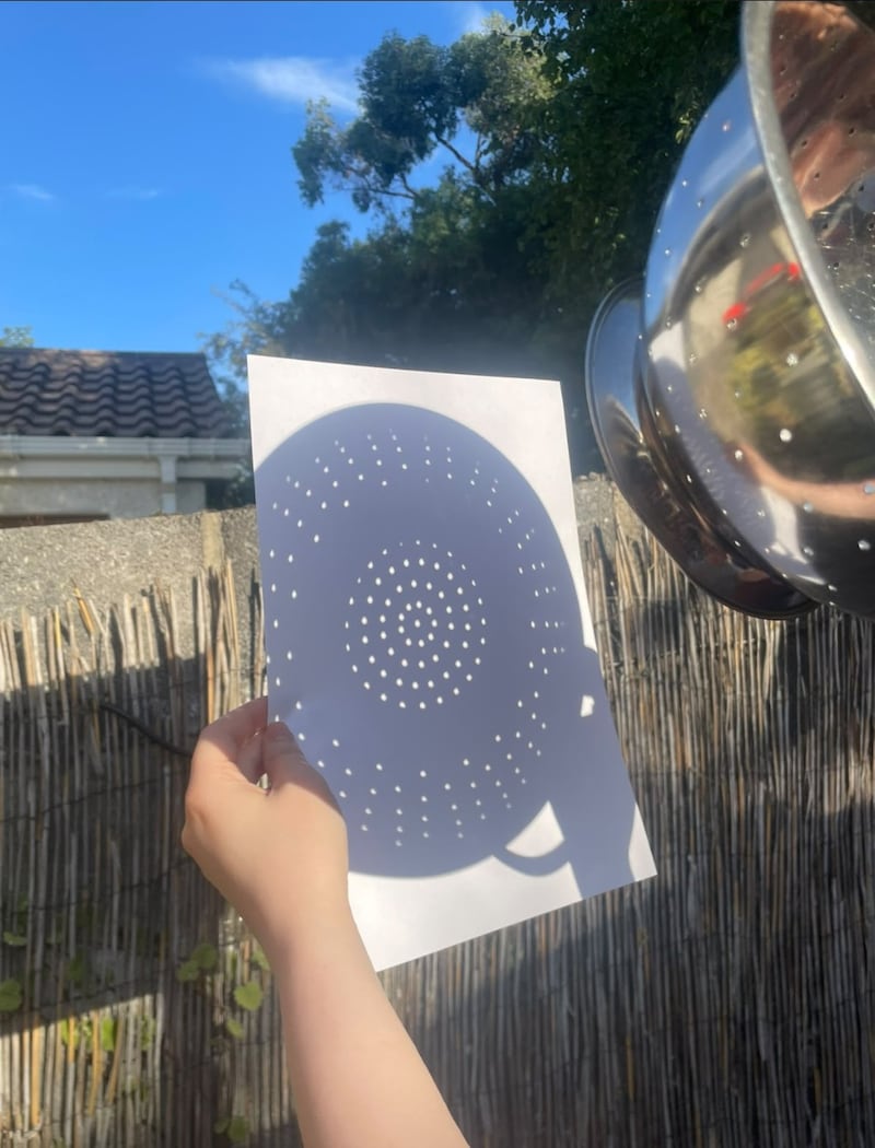 My solar eclipse 2026, by Caoimhe Donnelly, Dublin: “I never got round to buying solar glasses, and by the time it crossed my mind to order some online, it was too late. But my partner and I settled into the back garden, with the heat still in the air and a cold glass of wine. We ended up with a colander, backs to the sun, watching the little dot begin to disappear into a crescent. The birds flew off, and the light faded like a blanket being drawn over your eyes. I'm not sure I could truly explain what this light was like to someone who hadn't experienced it. During the peak of the solar eclipse, it felt like we were the last two people alive, plus our dog, Ron. And then it was over.”