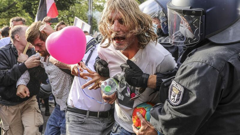 German riot police detain a protester as coronavirus sceptics  and right-wing extremists march in Berlin in protest against coronavirus-related restrictions. Photograph: Getty