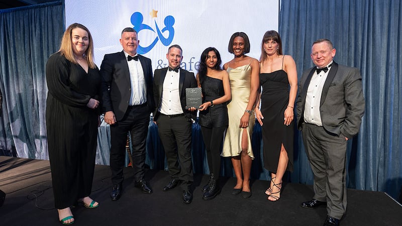 Julianne Shine, awards judge, presents the mental health and well-being initiative of the year to Ashview Consultants team