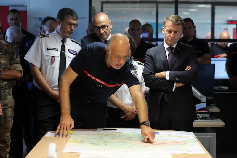 France's president Emmanuel Macron, right, and interior minister Laurent Nunez (centre back) attend a situation briefing in the crisis room at the Departmental Fire and Rescue Operational Center in Bordeaux on Monday. Photograph: Kenzo Tribouillard/AFP