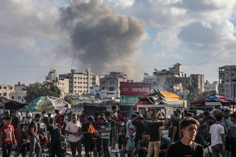 Palestinians gather as the smoke billows following an Israeli air strike on Gaza City. Photograph: Mohammed Saber/EPA