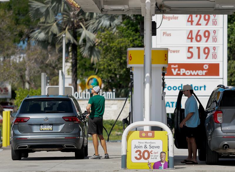 Fuel prices are displayed on a sign as customers fill their vehicles in Miami, Florida. Photograph: Joe Raedle/Getty Images
