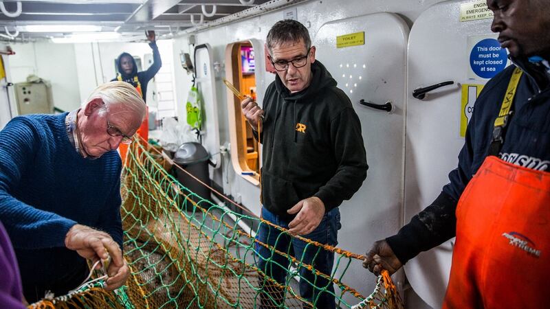 Philip Warnock, George Ado, Lawrence Warnock and Christopher Manah on the fishing boat Renown in Kilkeel harbour in Northern Ireland. Photo: James Forde for The Irish Times
