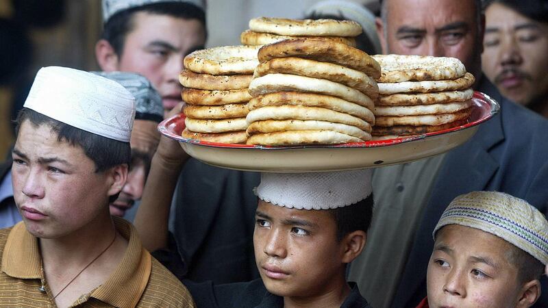 A Uighur boy carries a tray of flat bread for sale in a bazaar in Hotan in China’s northwest Xinjiang province. Photograph: Frederic J Brown/AFP/Getty