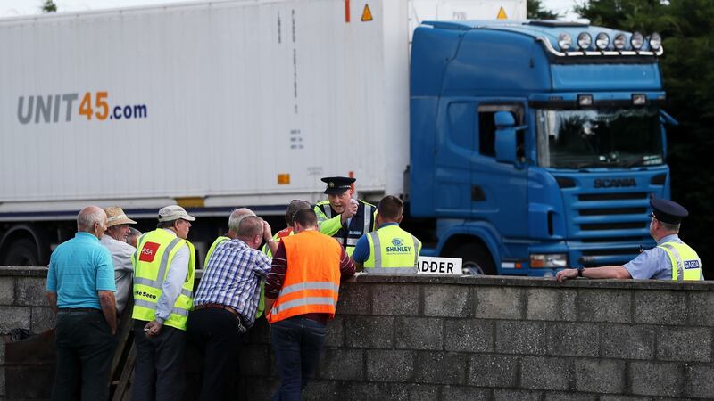 A garda in conversation with  independent farmers and supporters outside the Dawn Meats plant at Grannagh. Photograph: Brian Lawless/PA