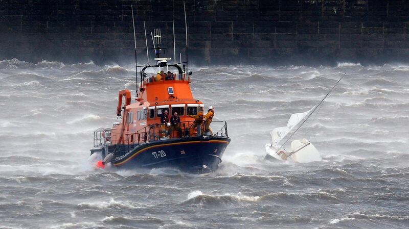 A Tynemouth RNLI Lifeboat recovers a small boat  after rescuing its participants following its capsizing in gale force wind in England. Photograph: Owen Humphreys/PA Wire