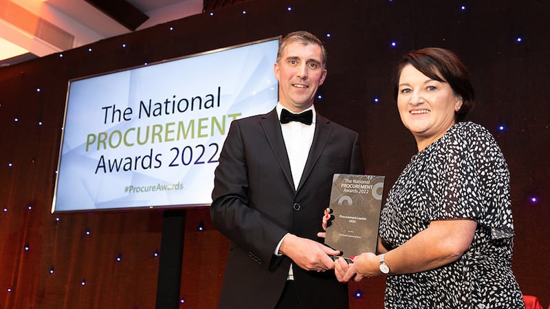 Francis Kehoe, Judging Co-ordinator, presents the Procurement Leader 2022 award to Catherine Cunningham on behalf of Michael Cunningham.